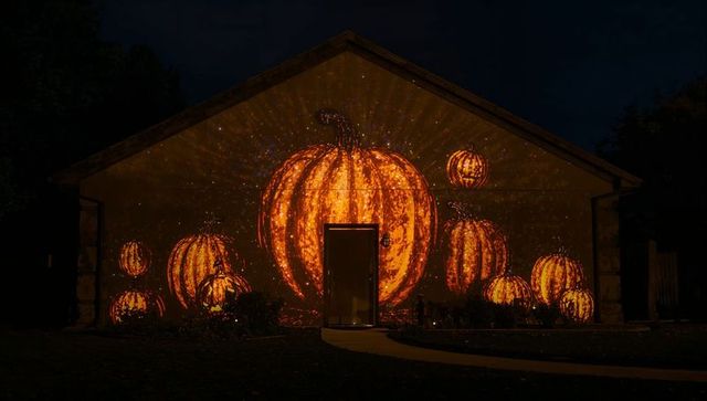 Festive Halloween Glowing Pumpkin Projection on Garage
