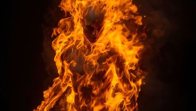 Burning figure engulfed in fiery transformation