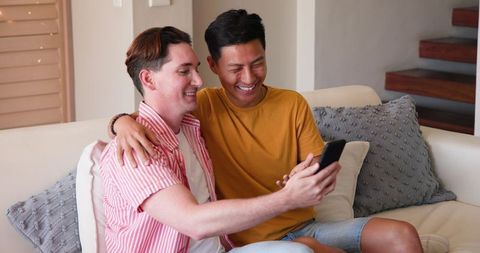 Happy Diverse Couple Video Calling at Home on Sofa