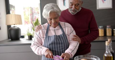Senior Couple Chopping Vegetables Together in a Cozy Kitchen