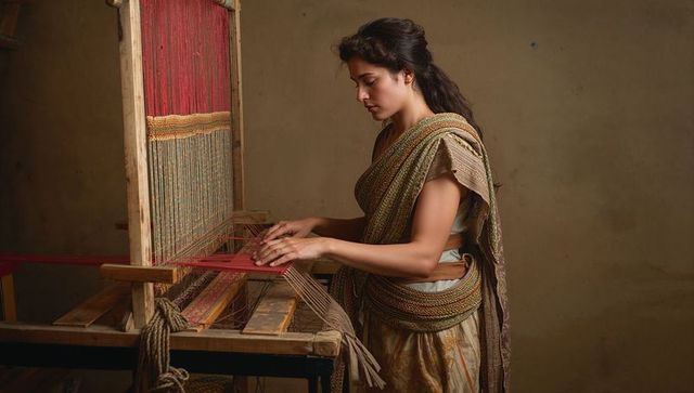 Weaving indian artisan crafting red handloom textile on wooden loom, traditional craft