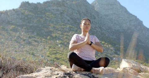 Woman in Meditation on Mountain Hike in Serene Landscape