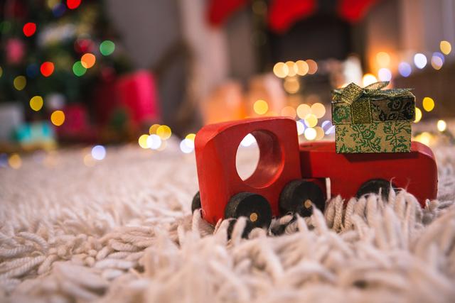 Toy Car Carrying Christmas Gift Box on Fur Carpet - Download Free Stock Photos Pikwizard.com