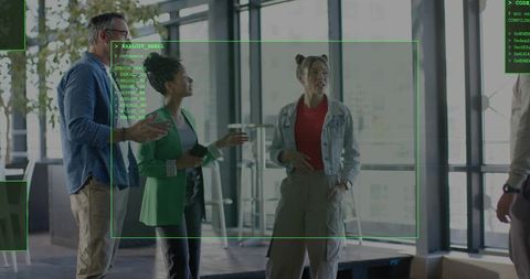 Startup team discussing augmented reality overlay during informal glass-walled office meeting
