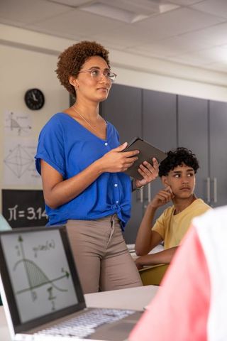 Teacher Presenting with Tablet in Tech-Enhanced Classroom