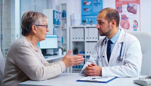 Senior woman discussing health with compassionate doctor in white coat and stethoscope