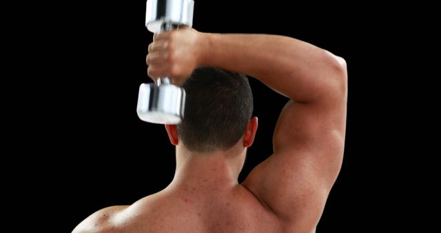 Shows a muscular man performing a tricep extension with a dumbbell, providing a detailed look at strength training exercises. Ideal for use in fitness blogs, workout guides, health magazines, or personal training promotional materials.