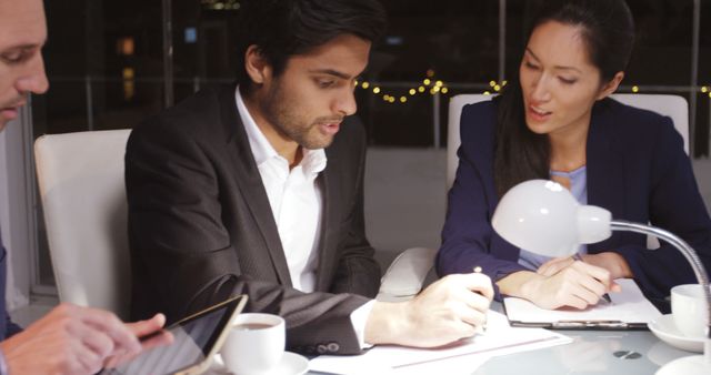 Team of business professionals collaborating during evening meeting - Download Free Stock Images Pikwizard.com