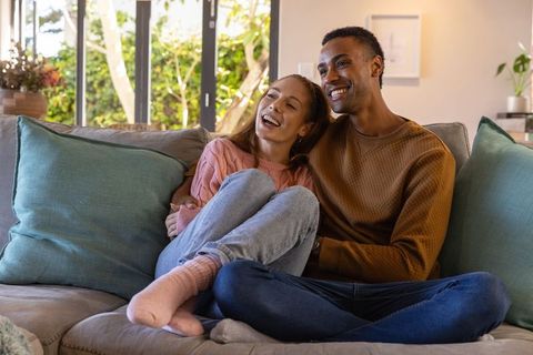 Happy Couple Relaxing on Cozy Sofa in Sunlit Living Room