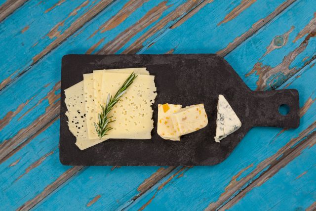 Cheese with rosemary on chopping board - Download Free Stock Photos Pikwizard.com