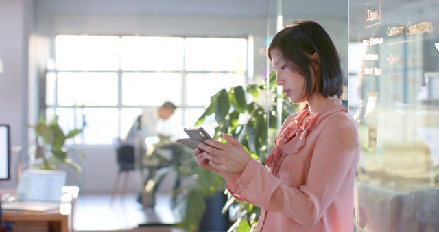 Businesswoman in Blouse Using Smartphone in Modern Office - Download Free Stock Images Pikwizard.com