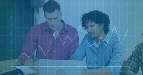Colleagues Analyzing Financial Data with Graph Overlay