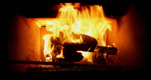 Image depicts burning firewood in a fireplace, creating warmth and a cozy atmosphere. This image can be used for illustrating articles about home decor, winter season, or promoting energy efficiency tips. Perfect for marketing content related to home heating solutions, relaxation products, or seasonal promotions.