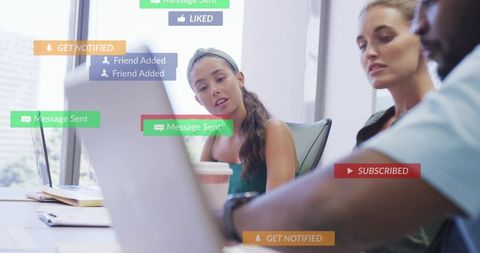 Young team collaborating over laptop with social media notification overlays and coffee