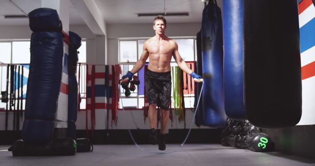 Shirtless Man Jump-Roping in Gym with Boxing Equipment - Download Free Stock Images Pikwizard.com