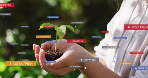 Asian female hands cupping seedling with soil and digital notifications symbolizing growth