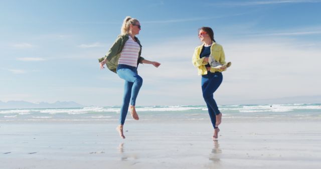 Happy two caucasian female friends having fun, walking along beach. holiday, freedom and leisure time outdoors.