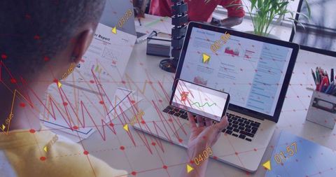 Business team reviewing analytics on laptop and smartphone with data overlays and charts
