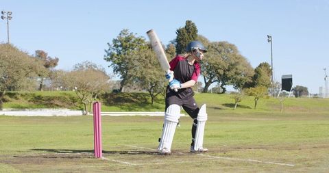 Female Cricket Player on Field with Pink Stumps Ready to Bat
