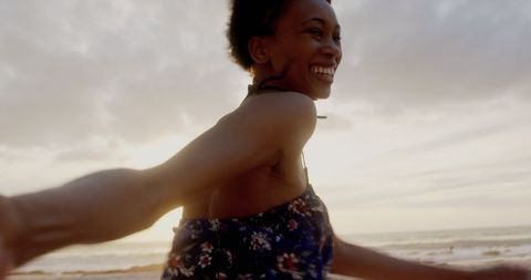 Joyful Lady Running on Beach at Sunset, Carefree and Smiling
