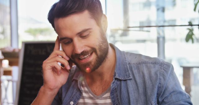 Smiling Man Taking Call During Work at Café - Download Free Stock Images Pikwizard.com