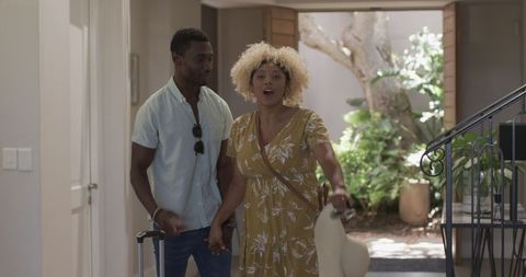 Couple entering home with joy on sunny day