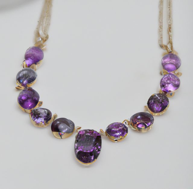 Gold necklace showcasing purple gemstones, including amethysts, isolated on a white background. Ideal for use in fashion editorials, luxury accessory advertising, jewelry store promotions, and online marketplace listings.