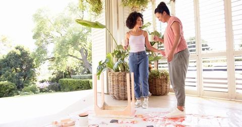 Mother and Daughter Enjoy DIY Painting Project on Sunlit Porch