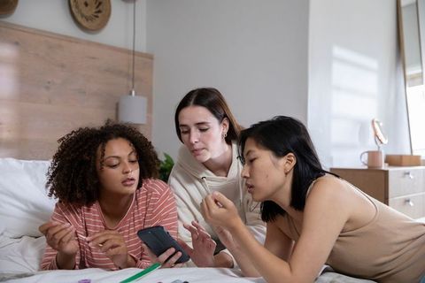 Diverse Women Bonding Over Smartphone Gathering