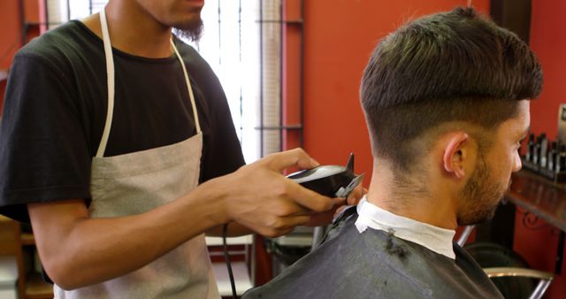 Barber Wearing Apron Trimming Man's Hair in Barbershop - Download Free Stock Images Pikwizard.com