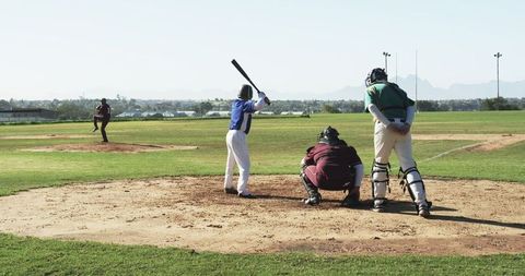 Youth baseball match on sunny field with players and umpire