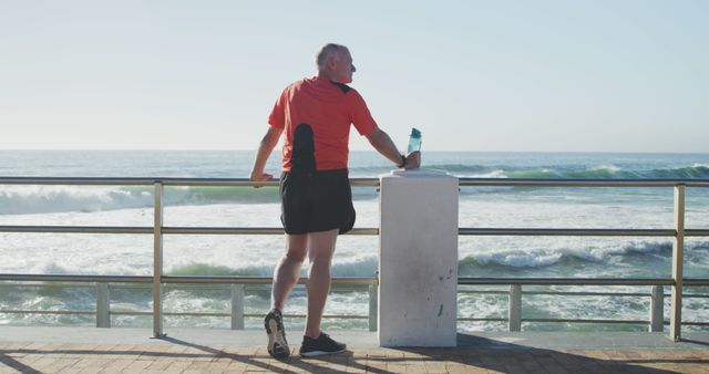 Senior Man Stretching by Ocean with Water Bottle - Download Free Stock Images Pikwizard.com