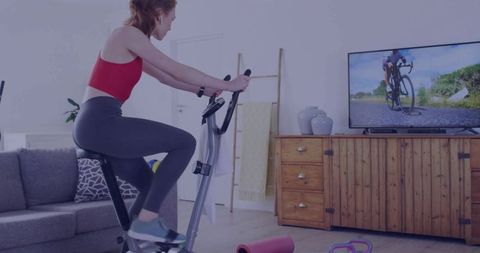 Woman Exercising on Stationary Bike in Modern Home Gym