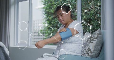 Asian woman monitoring blood pressure with digital interface concept