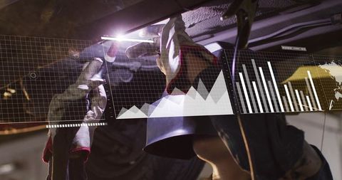 Mechanic inspecting undercarriage using torch while data overlay displaying diagnostics