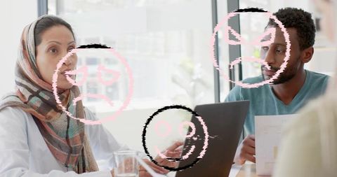 Team discussing project in bright office with woman wearing patterned headscarf gesturing