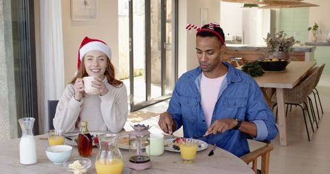 Festive breakfast: diverse couple shares pancakes in modern kitchen