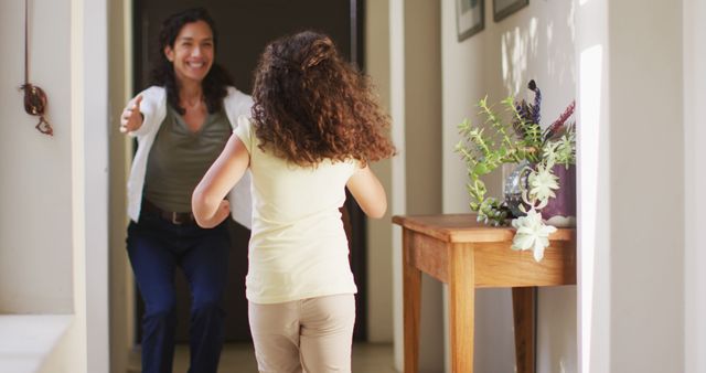 Mother joyfully welcoming daughter home in hallway - Download Free Stock Images Pikwizard.com