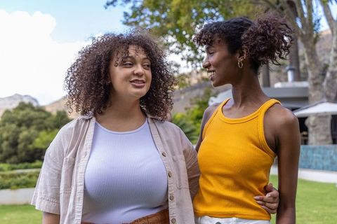 African american friends sharing happy conversation in backyard summer casual fashion