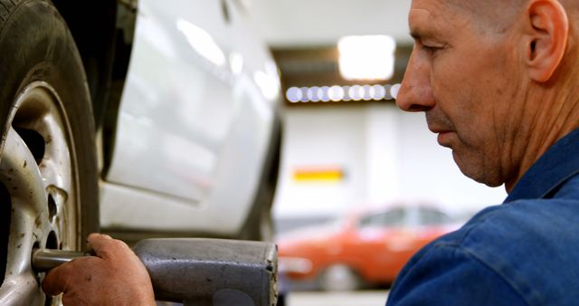 Auto Mechanic Fixing Wheel of Car in Workshop - Download Free Stock Images Pikwizard.com