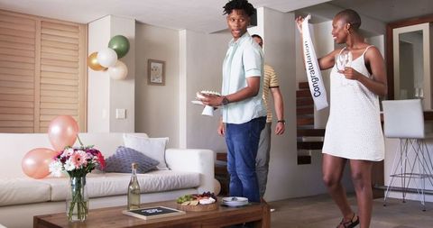Friends Setting up Birthday Party with Cake and Decorations at Home