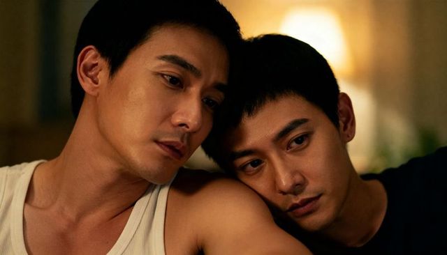Asian gay couple leaning together on couch at night warm intimate mood