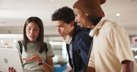 Young African American Students Collaborating on Laptop in Modern University Common Area