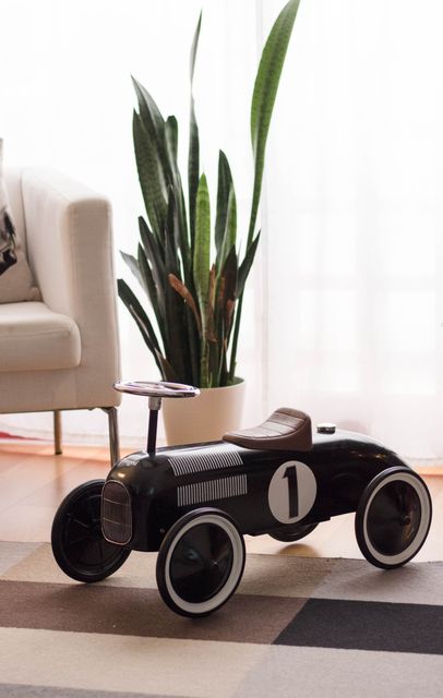 Vintage toy race car with houseplant and couch in background - Download Free Stock Photos Pikwizard.com