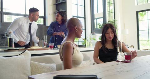 Diverse friends socializing at modern kitchen island enjoying drinks and conversation