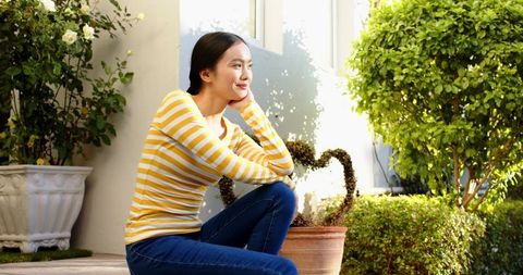 Woman Relaxing Outdoors Surrounded by Lush Greenery
