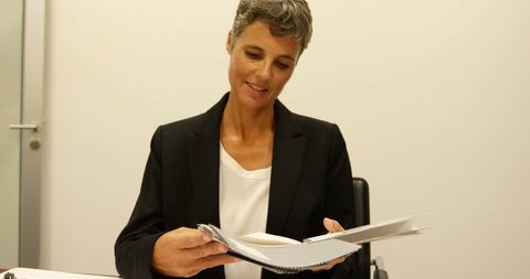 Mature businesswoman reviewing documents at office desk
