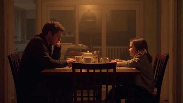 Father and Daughter Sharing Quiet Evening Tea at Wooden Table Under Warm Lamp