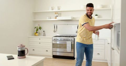 Smiling man in modern kitchen with milk bottle