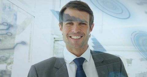 Confident businessman smiling in modern office with digital data interface overlays